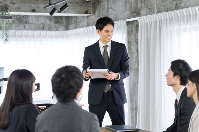 オフィスで新入社員を教育するビジネスマン