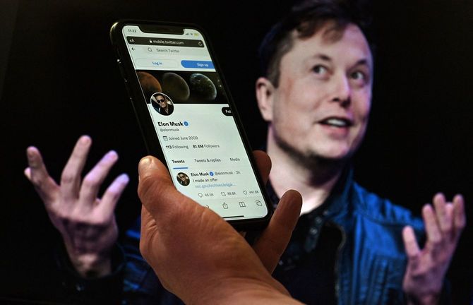 イーロン・マスクのTwitterアカウントと、イーロン・マスクの写真が、携帯電話の画面に表示されている