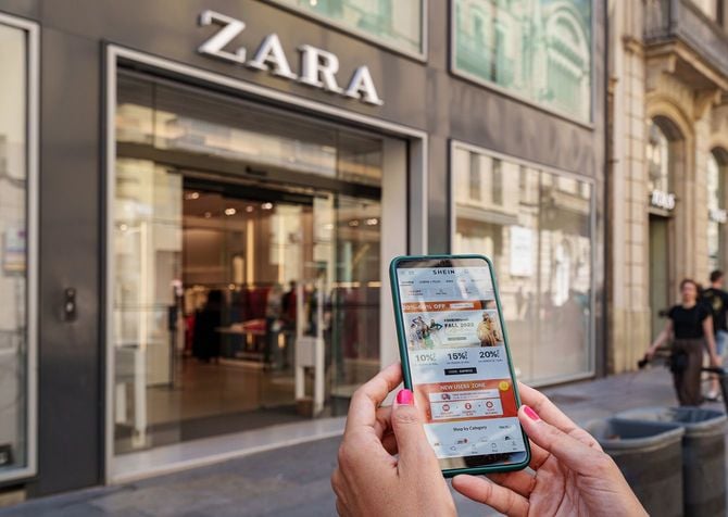 ZARAの店舗の前でシーインのサイトを見ている人