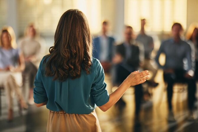 スピーチをしているビジネスウーマンの後ろ姿