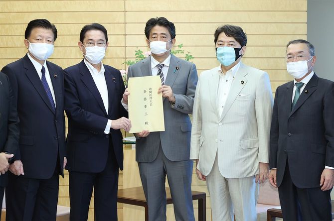 自民党経済成長戦略本部長の岸田文雄政調会長（左から2人目）から提言書を受け取る安倍晋三首相（中央）＝2020年6月25日、首相官邸
