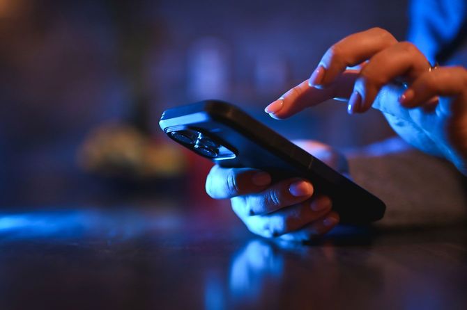 夜間にスマホを使用する人の手