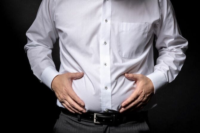 太った腹を気にする男性