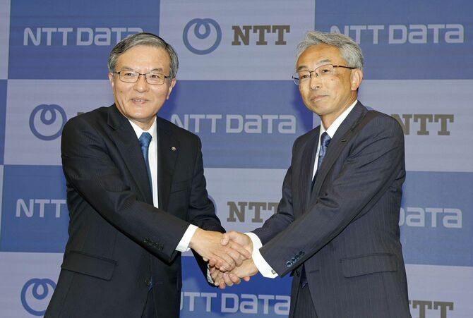 記者会見を終え、握手するNTTの島田明社長(左)とNTTデータグループの佐々木裕社長=2025年5月8日午後、東京都千代田区