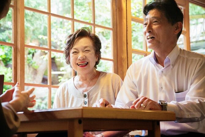友人との会話で笑う老夫婦
