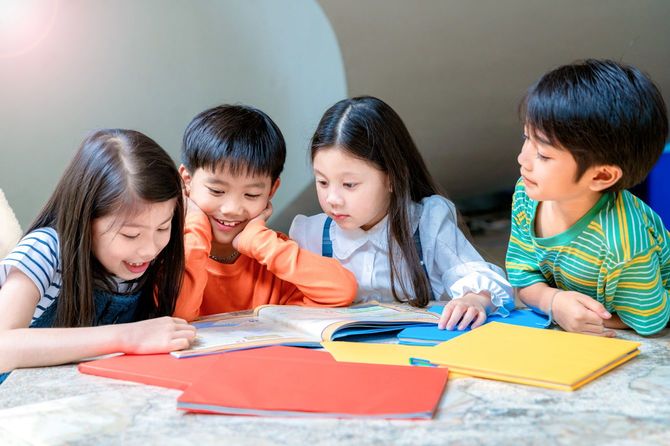 絵本を囲んでいる小学生のグループ