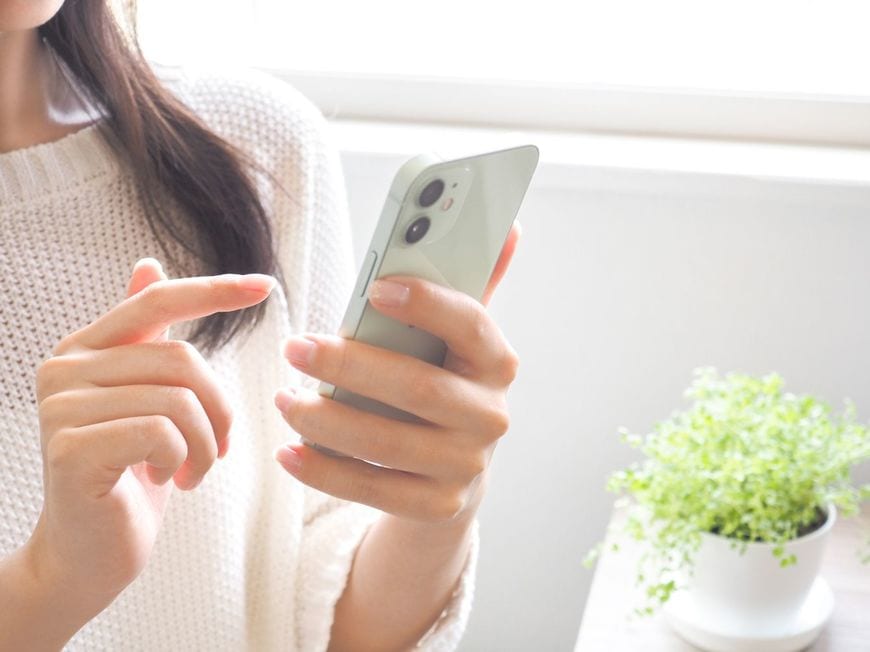 スマートフォンを使用している女性の手元