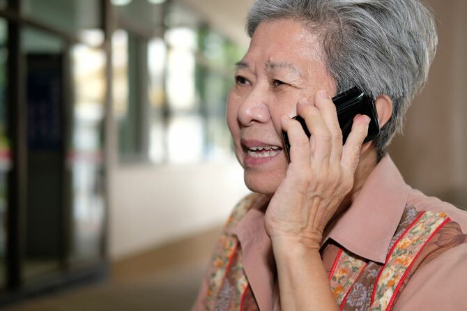 携帯電話で話す高齢の女性