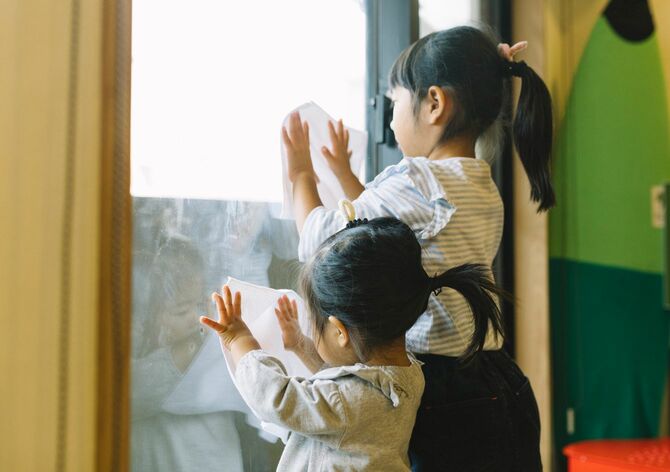 窓を掃除する女の子