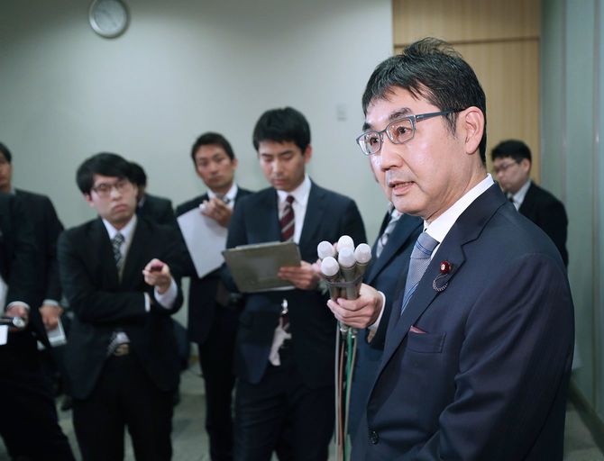 妻の案里参院議員の公職選挙法違反容疑で広島地検から地元事務所の家宅捜索を受けたことについて、記者の取材に応じる自民党の河井克行前法相(右手前)