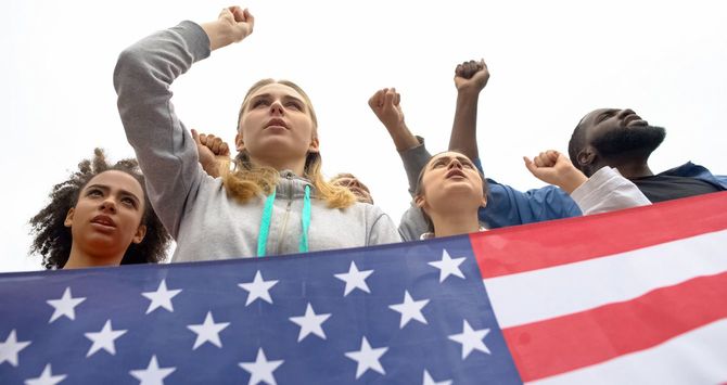 米国旗を掲げスローガンを唱える活動家たち