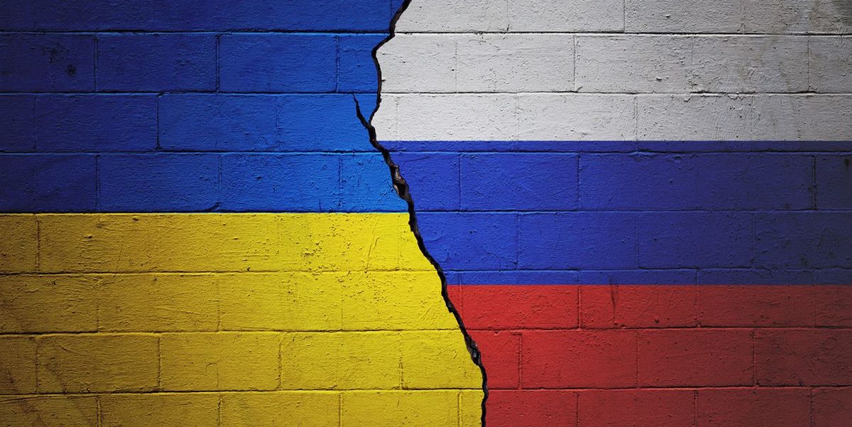 ひび割れの入った壁に描かれたウクライナとロシアの国旗
