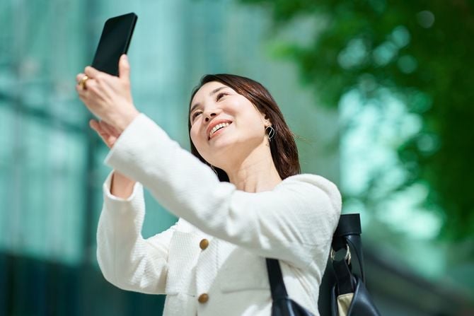 屋外でスマートフォンを持つ女性