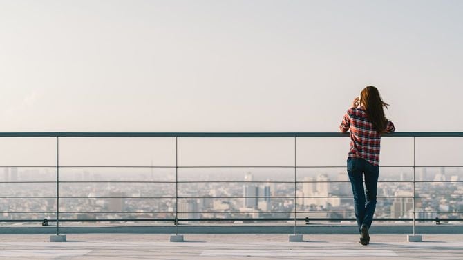 屋上で携帯電話を使用する女性