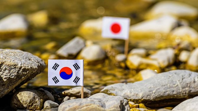 川を挟んで韓国の国旗と、日の丸