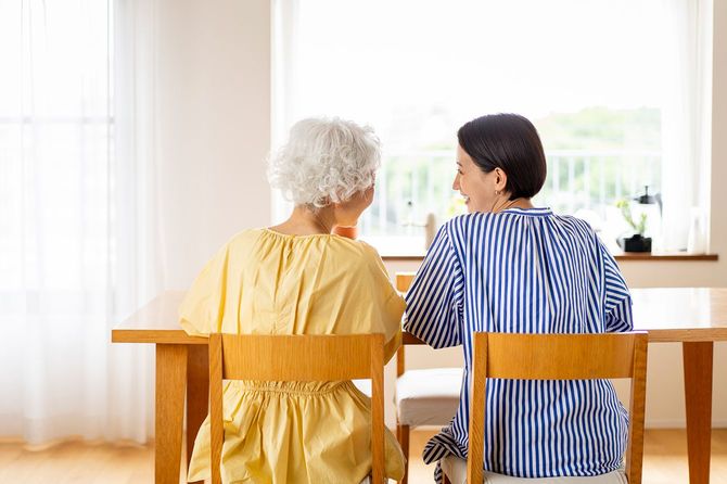 シニア女性と中年女性がダイニングで話す