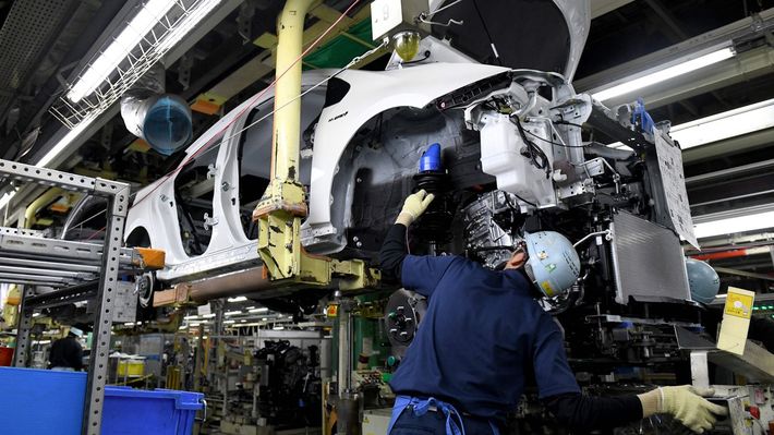 トヨタ自動車の堤工場（愛知県豊田市）の生産ラインで、4代目プリウスにエンジン部を組み付ける作業員たち＝2017年12月8日