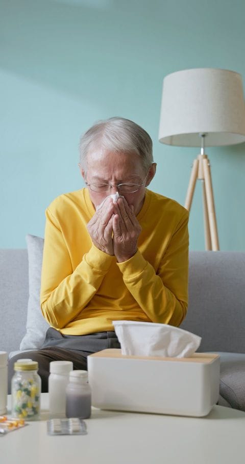 鼻をかんでいるシニア男性