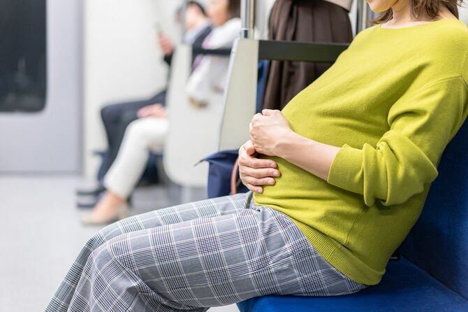 電車の座席に座る妊婦