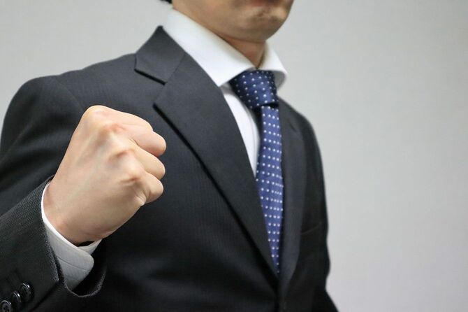 拳を握るスーツの男性