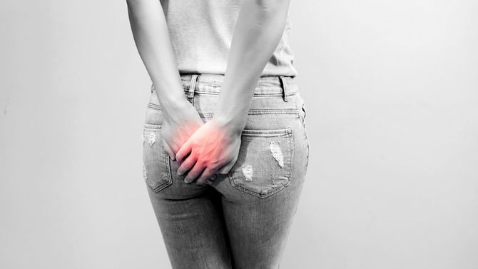 痔の痛みのため、お尻のあたりに手をやる女性