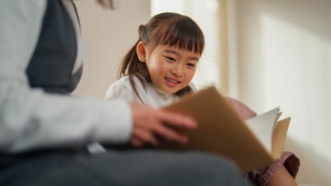 娘に本を読み聞かせる母親