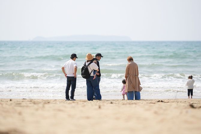 海辺の砂浜で遊ぶ家族