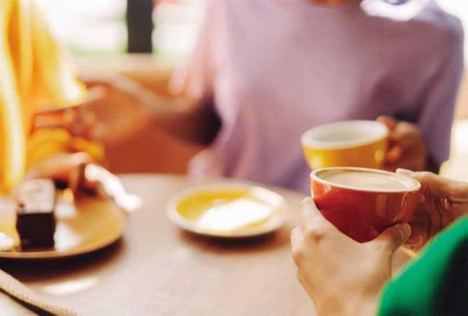 友人とカフェで話す人