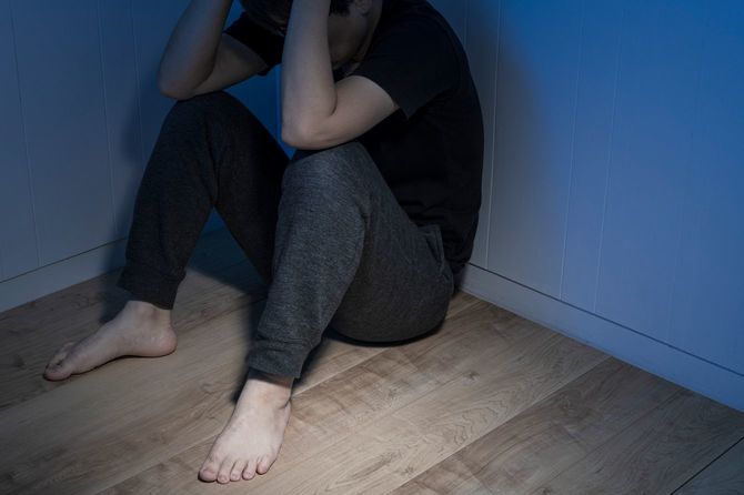 暗い部屋で途方に暮れる男