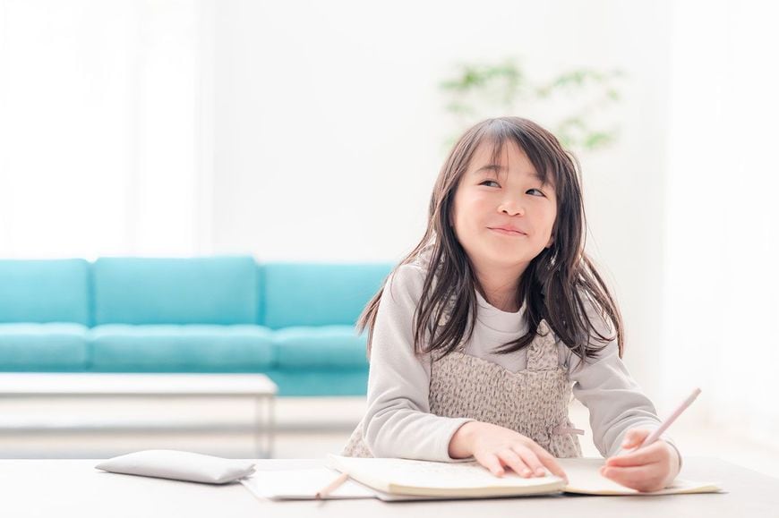 リビングルームで勉強をする子供