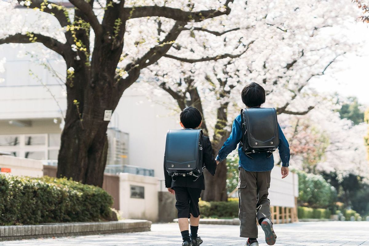 手をつないで登校する2人の小学生