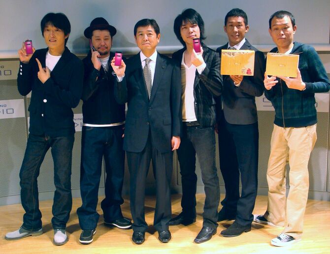 KDDIが11月12日に発売する「よしもとケータイ」を手にする麒麟の川島明さん（右から3人目）ら。同4人目はKDDIの雨宮俊武コンテンツ・メディア本部長（＝東京都内、2008年10月16日）