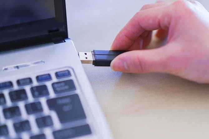 パソコンにUSBメモリを挿す人の手元