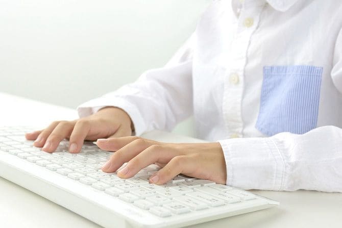 パソコンのキーボードを操作する子どもの手