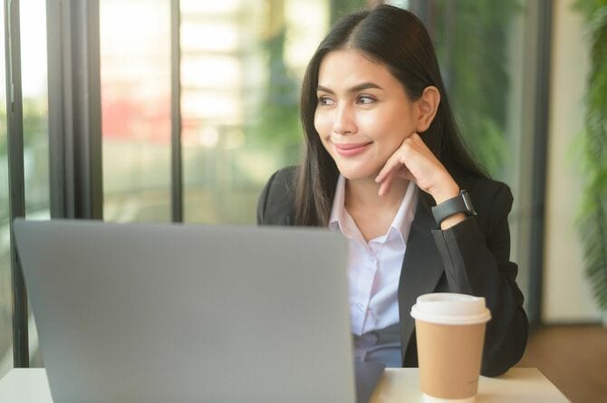 コーヒーを喫茶店で飲みながら仕事するビジネスマン