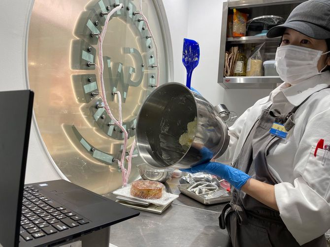 大阪の石川シェフと沖縄の厨房をZoomでつないで新商品の試作をするパティシエの大工真理枝さん＝6月9日、那覇市久茂地・GOLDWELL