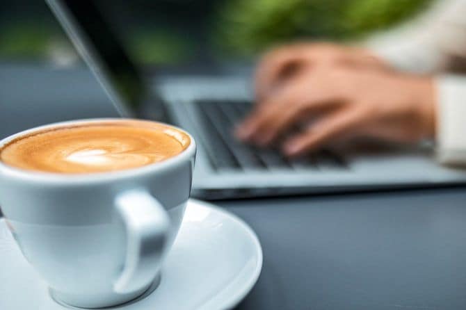 ノートパソコンを使う人とコーヒー