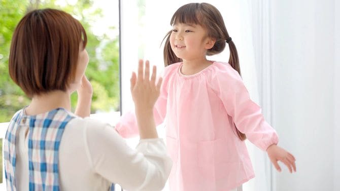 園児とハイタッチしようとしてる保育士