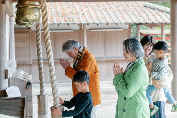 日本のお寺で祈る多世代家族。岡山県, 日本
