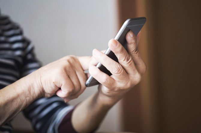 スマートフォンを使用する年配の女性