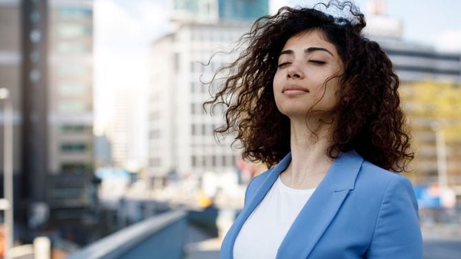 屋外で深呼吸をするビジネスウーマン