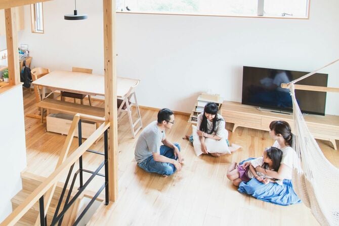 リビングで会話をする4人の家族