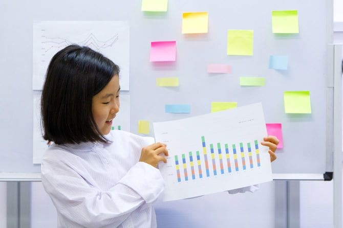 グラフが書かれた紙を持つ子供