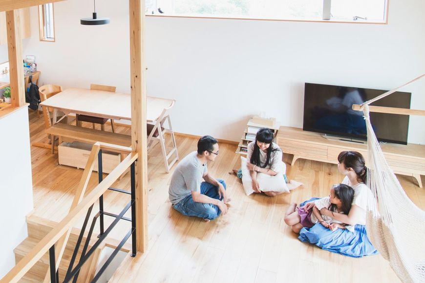 リビングで会話をする4人の家族