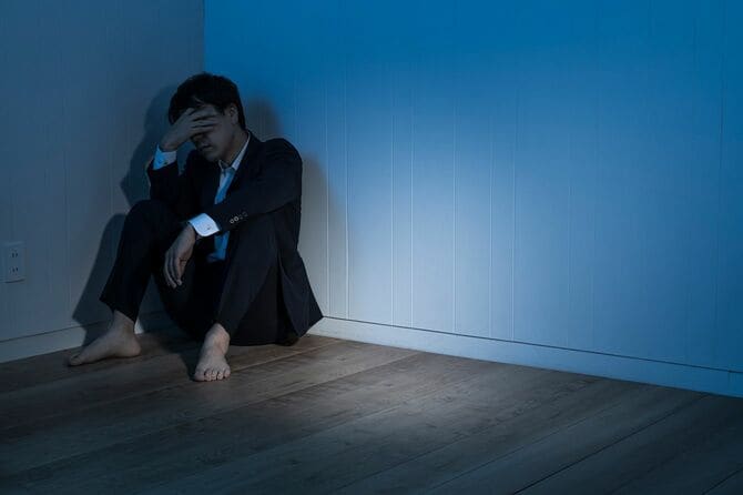 暗い部屋で途方に暮れた男