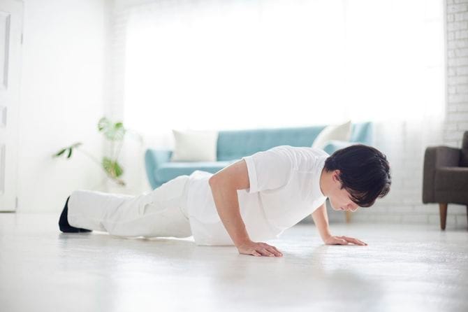 リビングで腕立て伏せをしている若い日本人男性