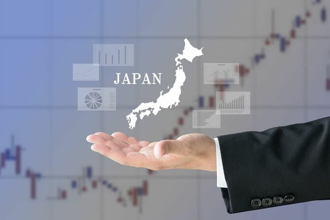 株価チャートの背景にビジネスマンの手と日本の地図