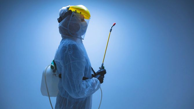 除染のための化学噴霧器を保持している科学者