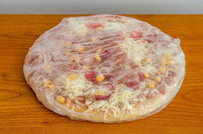 机の上に凍ったままの冷凍ピザ