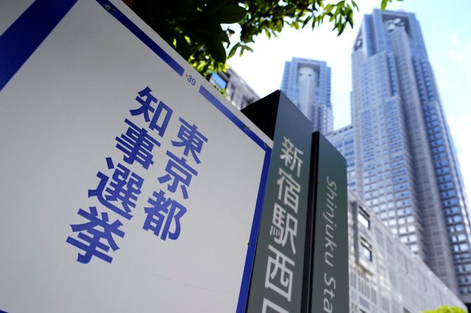 東京都知事選のポスター掲示場と都庁舎（東京都新宿区、2024年6月24日）